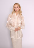 Front view of the BRISTOWE Mirage Shirt in sheer ivory, with long sleeves and chest pockets, worn loose over a sequin skirt