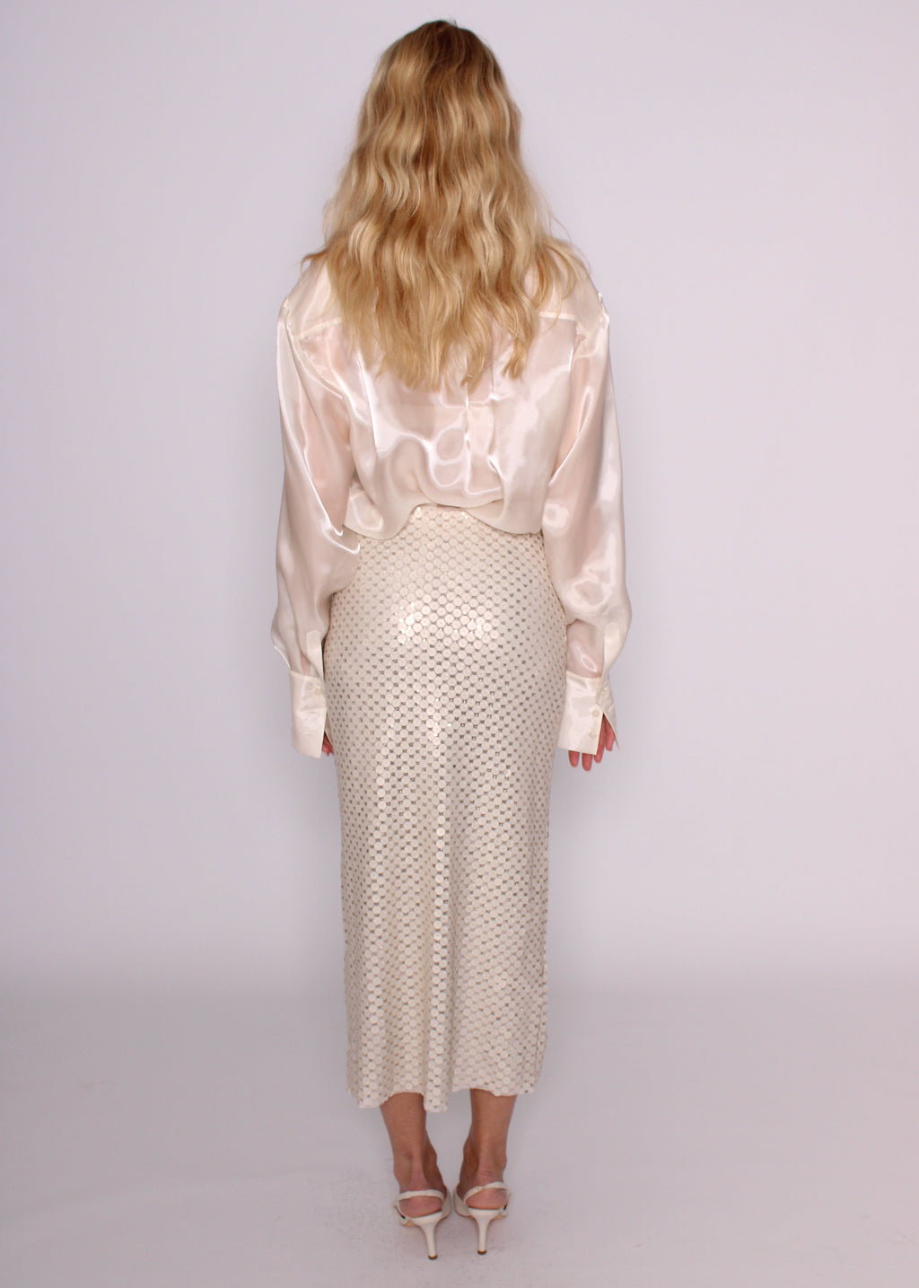 Back view of the BRISTOWE Corine ivory sequin maxi skirt showing its shimmering texture, styled with an ivory shirt.
