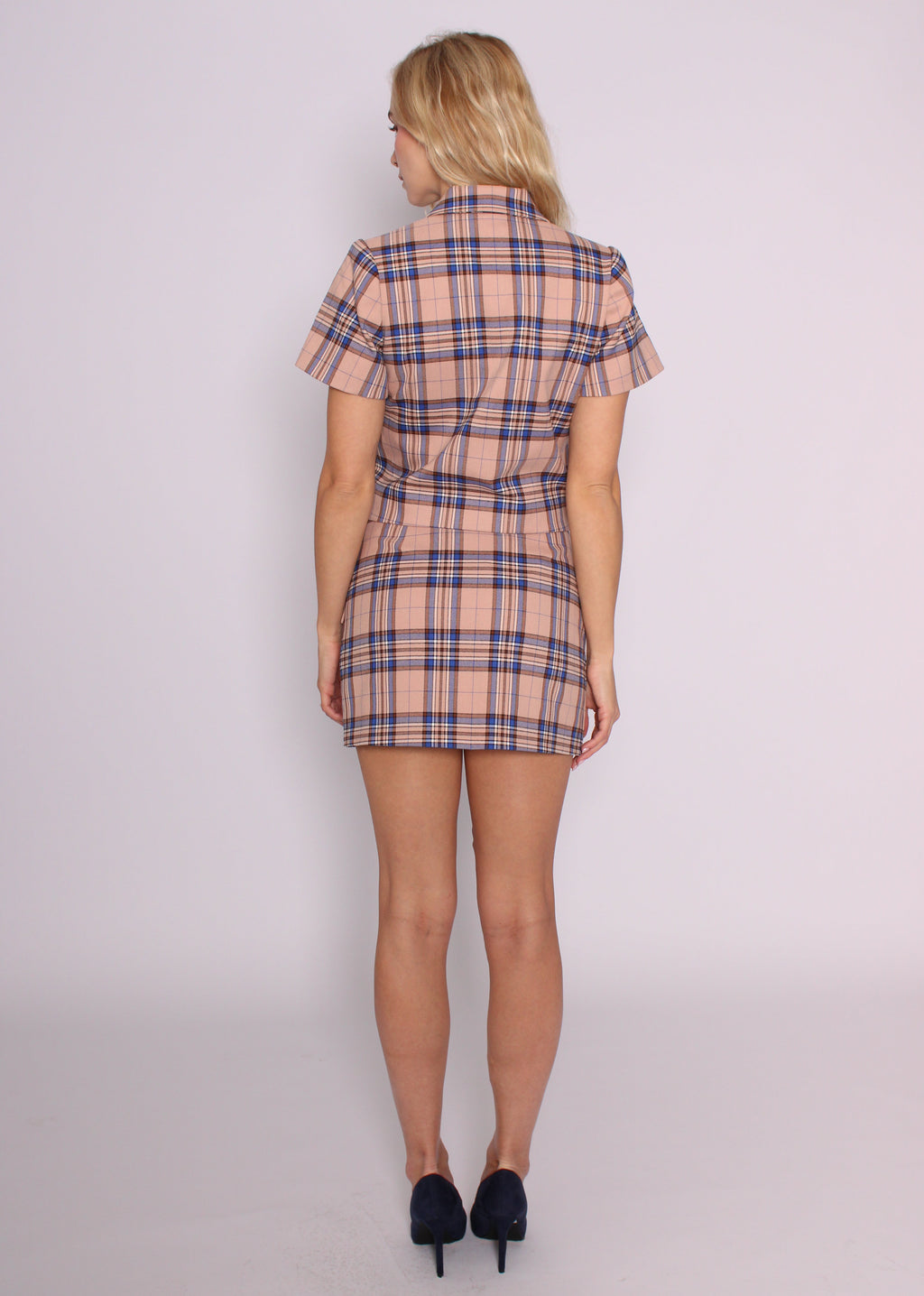 Back view of the BRISTOWE Inez blush tartan mini skirt, worn with the matching cropped top.