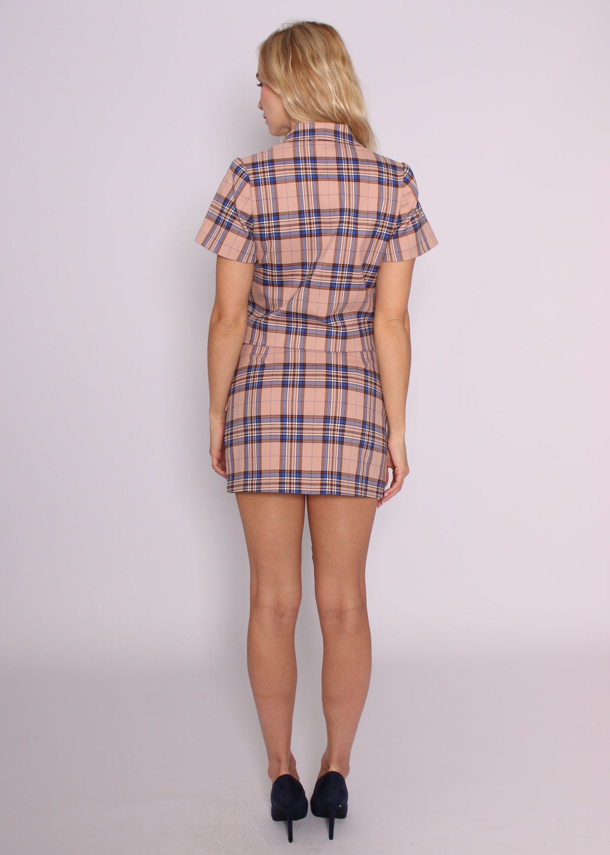 Back view of the BRISTOWE Inez blush tartan mini skirt, worn with the matching cropped top.